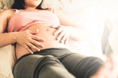 Mutlu hamile bir kadın ve evde bebek bekliyor..