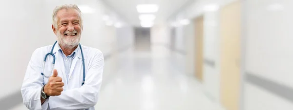 Szczęśliwy starszy lekarz stojący w szpitalu. — Zdjęcie stockowe
