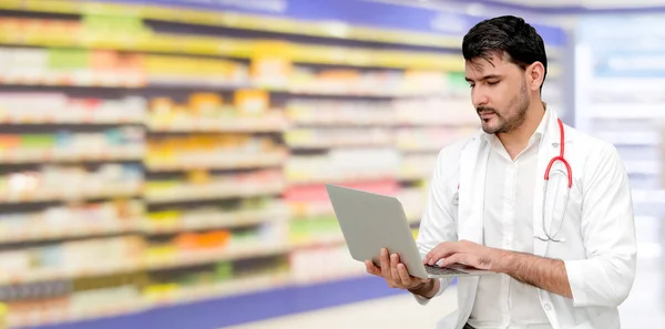 Farmacéutico usando computadora portátil en farmacia . — Foto de Stock