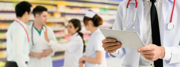 Dokter werkzaam in het ziekenhuis met andere artsen. — Stockfoto