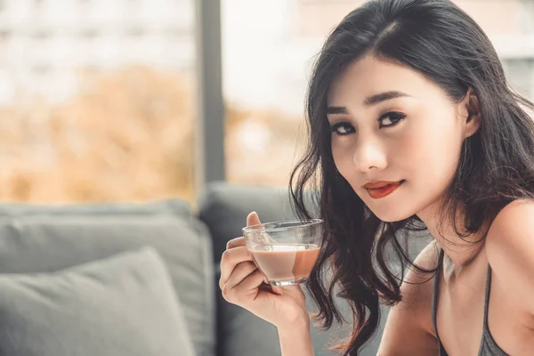 Mladá asijská žena pije kávu ráno. — Stock fotografie