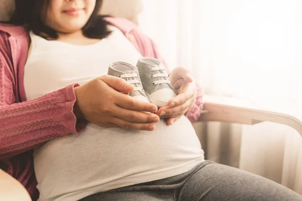 Mujer embarazada feliz y esperando un bebé en casa. — Foto de Stock