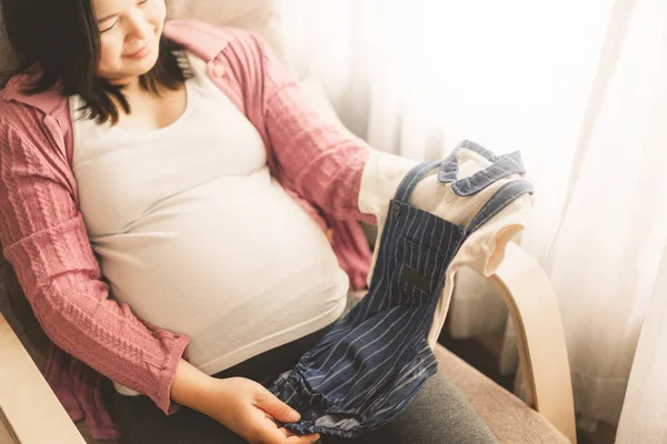 Mujer embarazada feliz y esperando un bebé en casa. — Foto de Stock