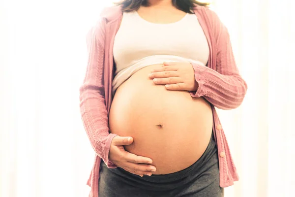 Mujer embarazada feliz y esperando un bebé en casa. —  Fotos de Stock