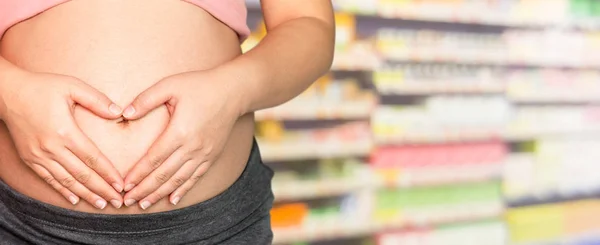 Беременная женщина в аптеке или аптеке . — стоковое фото