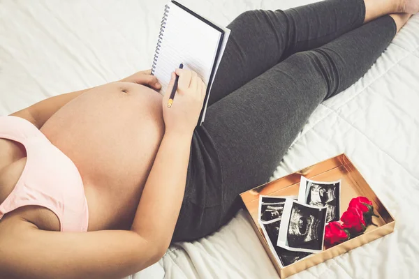 Mujer embarazada feliz y esperando un bebé en casa. — Foto de Stock