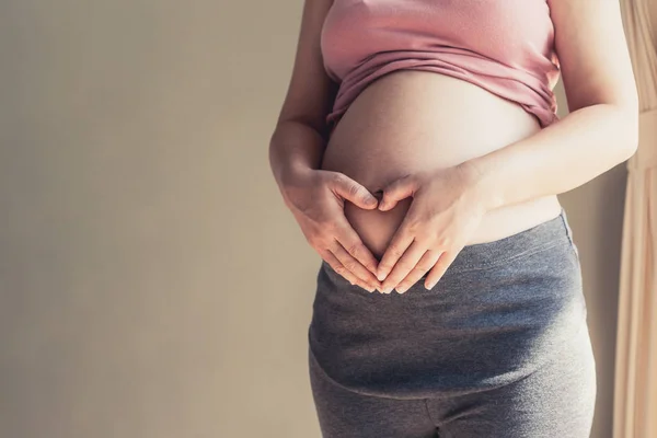 Mujer embarazada feliz y esperando un bebé en casa. — Foto de Stock