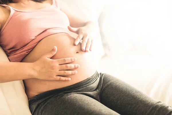 Happy pregnant woman and expecting baby at home.