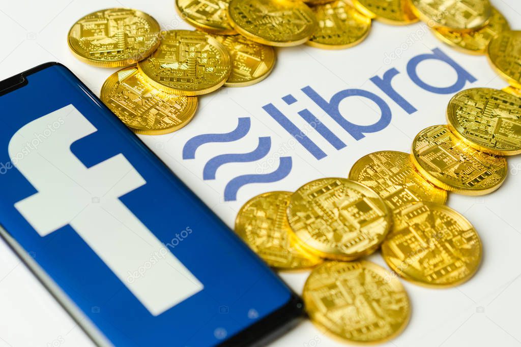 Bangkok, Thailand - July 2, 2019: Phone with Facebook logo on screen is placed on paper with Libra logo. Facebook reported to utilize new cryptocurrency called Libra expected to be used on Facebook.