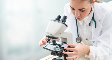 Bilim adamı araştırmacı laboratuvarda mikroskop kullanır