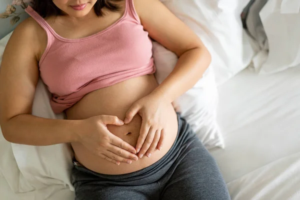 Mujer embarazada feliz y esperando un bebé en casa. — Foto de Stock