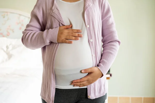 Mujer embarazada feliz y esperando un bebé en casa. — Foto de Stock