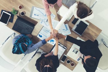 Takım çalışması çalışanları toplantıda el ele tutuşuyor.