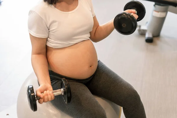 Активні фізичні вправи вагітної жінки у фітнес-центрі . — стокове фото