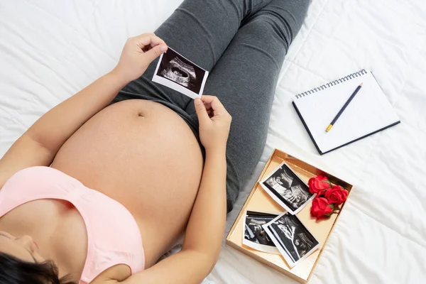 Mujer embarazada feliz y esperando un bebé en casa. — Foto de Stock