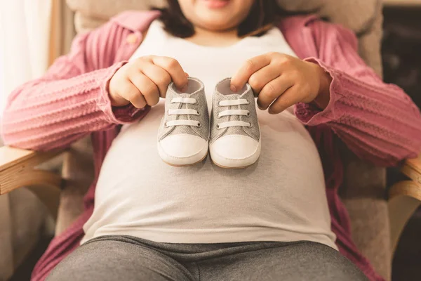 Mujer embarazada feliz y esperando un bebé en casa. — Foto de Stock