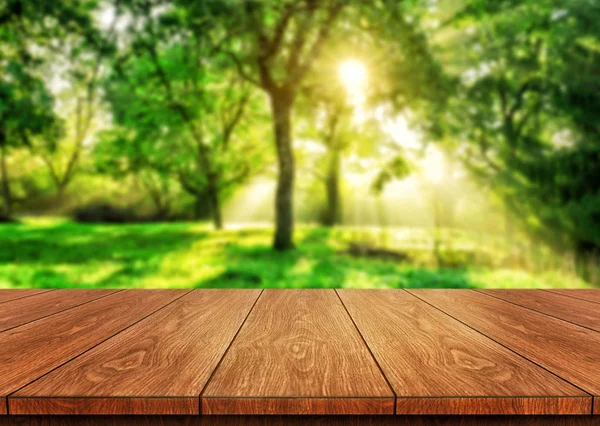 Brunt träbord i grön oskärpa natur bakgrund. — Stockfoto