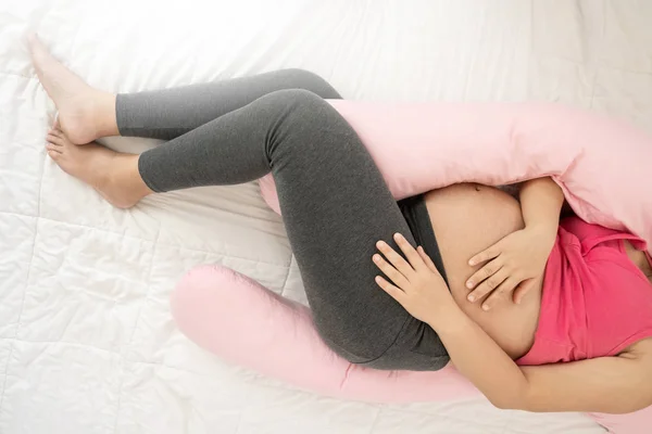 Mujer embarazada feliz durmiendo en la cama en el dormitorio. — Foto de Stock