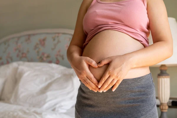 Mujer embarazada feliz y esperando un bebé en casa. — Foto de Stock