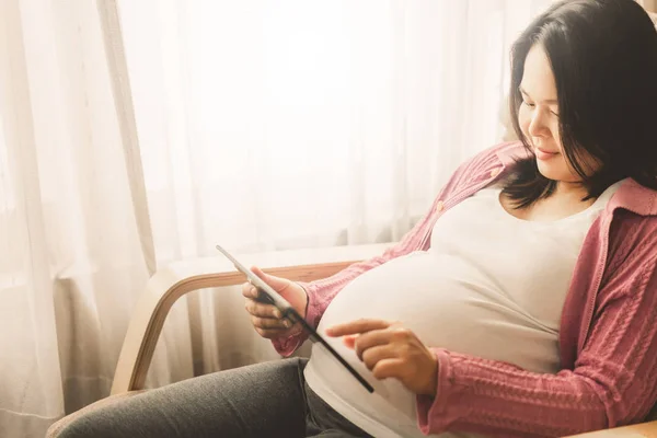 Mujer embarazada feliz y esperando un bebé en casa. — Foto de Stock