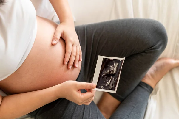 Mujer embarazada feliz y esperando un bebé en casa. — Foto de Stock