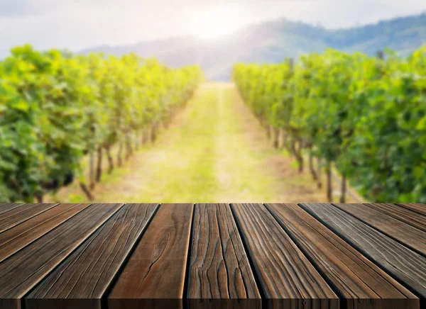 コピースペース付きの緑の春のブドウ園の風景の茶色の木製のテーブル — ストック写真
