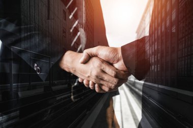 Arka planda iş adamları el sıkışma çift pozlama görüntü iş anlaşmasının ortaklık başarısını gösteren. Kurumsal ekip çalışması, güven ortağı ve iş sözleşmesi kavramı.