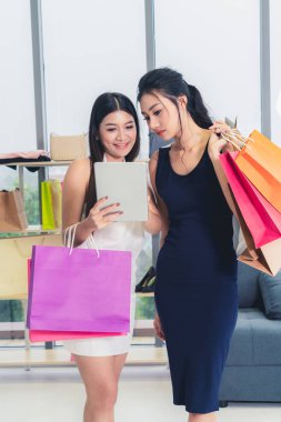 İki Asyalı kadın alışveriş merkezinde perakende mağazasında alışveriş. Modern ticaret yaşam tarzı.