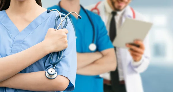 Médico que trabalha no hospital com outros médicos . — Fotografia de Stock