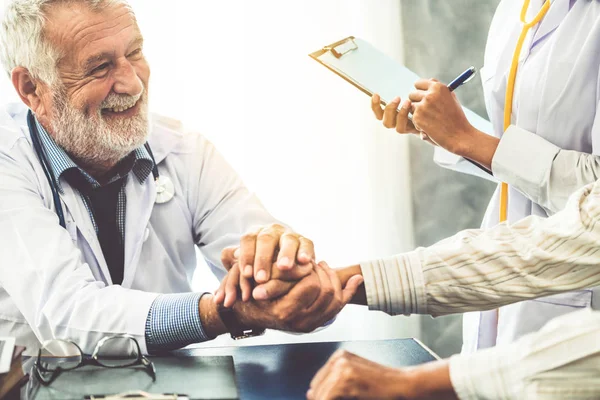 Senior arts praten met de patiënt in het ziekenhuis. — Stockfoto