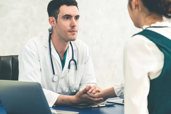 Young doctor examining patient in hospital office. — Stock Photo, Image