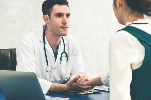 Jovem médico examinando paciente em consultório hospitalar . — Fotografia de Stock