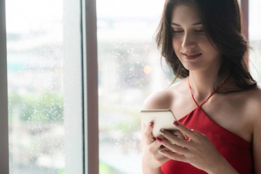 Kahve dükkanında akıllı telefon kullanan mutlu kadın.