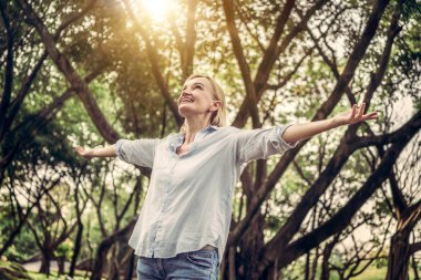 Parkta duran mutlu orta yaşlı kadın.