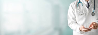 Hastanede cep telefonu kullanan bir erkek doktor..