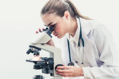 Hastane laboratuvarında mikroskop kullanan doktor.