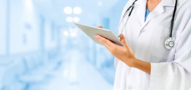 Hastanede tablet bilgisayar kullanan bir doktor..