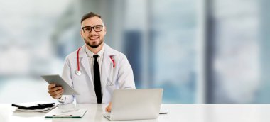 Hastanede tablet bilgisayar kullanan bir doktor..