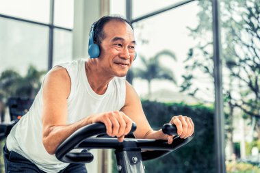 Fitness merkezinde bisiklet makinesi üzerinde Kıdemli adam egzersiz