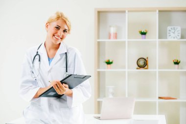 Hastane ofisinde çalışan genç kadın doktor.