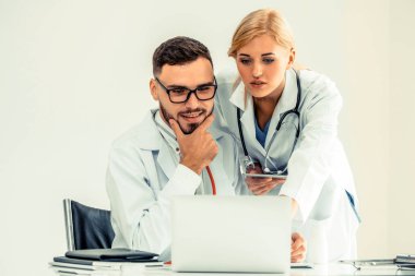 Hastanedeki doktor ortağıyla bilgisayar başında çalışıyor.