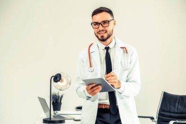 Hastanede tablet bilgisayar üzerinde çalışan doktor.