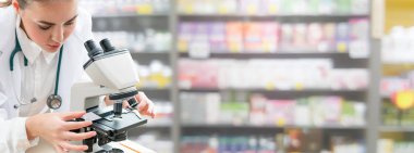 Bilim adamı araştırmacı laboratuvarda mikroskop kullanır