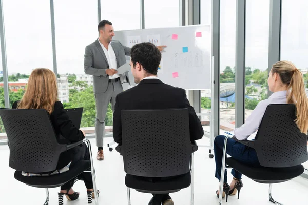 Businesswomen and businessmen in group meeting.