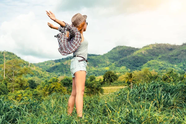 Mulher feliz no campo verde e fundo da montanha — Fotografia de Stock