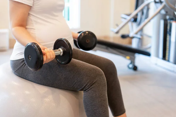 Ejercicio activo de mujer embarazada en el gimnasio. —  Fotos de Stock