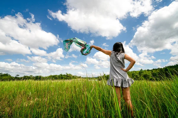 Młoda kobieta na zielonej trawie rozprzestrzeniania broni do nieba. — Zdjęcie stockowe