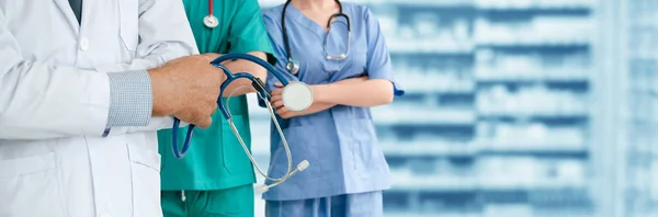 Médico que trabalha no hospital com outros médicos . — Fotografia de Stock