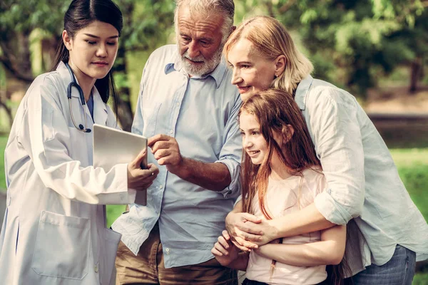 Heureux en bonne santé famille et médecin parlant dans le parc . — Photo