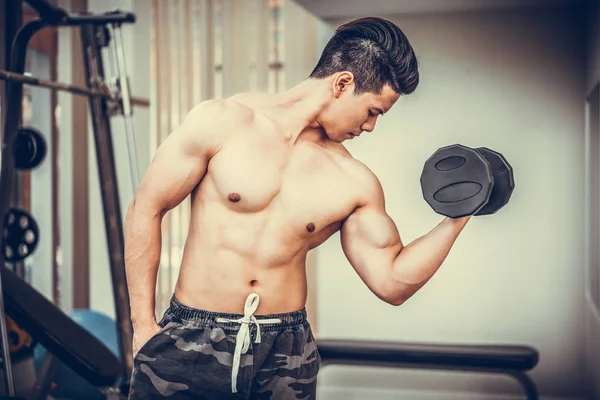 Μυώδης άνδρας bodybuilder κατάρτισης με αλτήρες. — Φωτογραφία Αρχείου